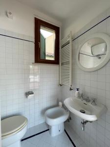 ファーノにあるCasa Apolloni 40の洗面台とトイレを備えた白いバスルーム +4枚の写真