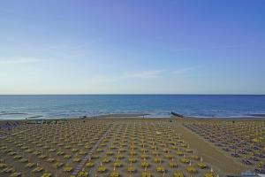 an empty beach with umbrellas and the ocean at Hotel Strand a frontemare in Lido di Jesolo