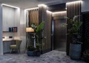 a hallway with potted plants in a room with a desk at Letoh Letoh Gran Vía in Madrid