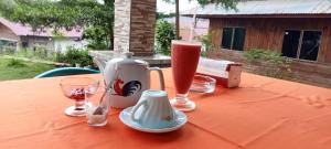a table with a tea kettle and glasses on it at Toraja Bungin Family House in Rantepao