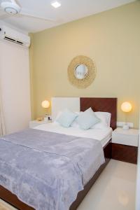 a bedroom with a large bed with blue pillows at ARON'S Lavinia RUBY in Mount Lavinia