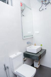 uma casa de banho com um WC branco e um lavatório. em ARON'S Lavinia RUBY em Mount Lavinia