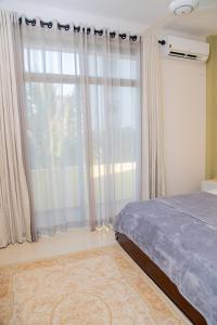 a bedroom with a bed and a large window at ARON'S Lavinia RUBY in Mount Lavinia