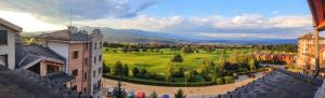 een uitzicht op een stad met een groen veld en gebouwen bij Mountain View Pirin Golf in Bansko