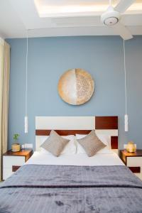 um quarto com uma cama com uma parede azul em ARON'S Lavinia TOPAZ em Mount Lavinia