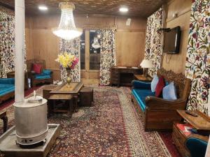a living room with a couch and a tv at Lake Victoria Houseboats in Srinagar