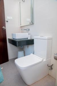 a bathroom with a white toilet and a sink at ARON'S Lavinia EMERALD in Mount Lavinia