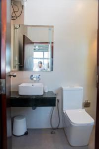 uma casa de banho com um lavatório, um WC e um espelho. em ARON'S Lavinia EMERALD em Mount Lavinia