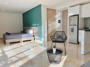 een slaapkamer met een bed en een stoel in een kamer bij Rentas Vacacionales Torre Diez in Playa del Carmen