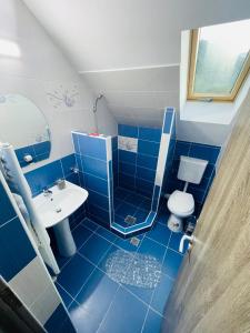 Baño azul con lavabo y aseo en Casa Korina, en Azuga
