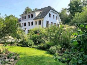 uma grande casa branca com um jardim em frente em Alte Mühle em Holzminden