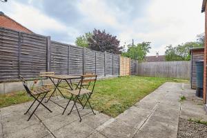 a table and chairs in a backyard with a fence at Royal Derby Hospital Mickleover Town House in Derby