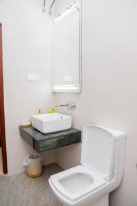 a bathroom with a white toilet and a sink at ARON'S Lavinia SAPPHIRE in Mount Lavinia