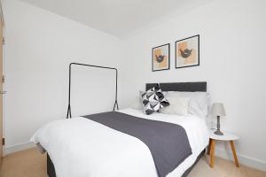 een slaapkamer met een wit bed en een zwart-witte deken bij Royal Derby Hospital Mickleover Town House in Derby