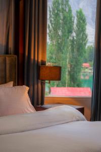 ein Schlafzimmer mit einem Bett und einem großen Fenster in der Unterkunft Tibet Hotel in Skardu