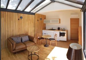 een woonkamer met een bank en een tafel bij Le mazet des amants, cabane en bois avec jacuzzi privatif in Avignon