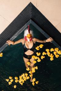 une femme dans une piscine remplie de nourriture de canard dans l'établissement Hotel Christof, à Monguelfo-Tesid