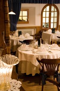uma sala de jantar com mesas com mesas brancas em Hotel La Villa em La Villa