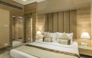 杜尔加布尔The Citi Residenci Hotel - Durgapur的卧室里有一张白色的大床，床边还有两盏灯