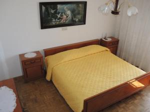 a bedroom with a yellow bed and two night stands at Apartment Rita RM in Portorož