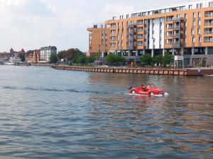 a person in a red car in the water at Old Town Nadmotławie - Sauna & Gym I 10min deptak in Gdańsk