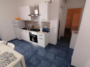 una cucina con armadi bianchi e pavimento piastrellato blu di Villa Azul Carratois a Portopalo