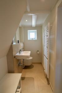 een badkamer met wastafel en toilet bij Appartement Backbord in Hörnum