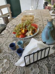 un plato de comida en una mesa con un plato de fruta en To Spiti Tou Papa Sto Vouno en Kamilari