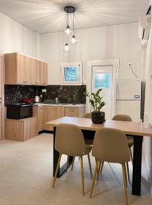 a kitchen with a table and chairs and a refrigerator at Central neighborhood house in Stalida
