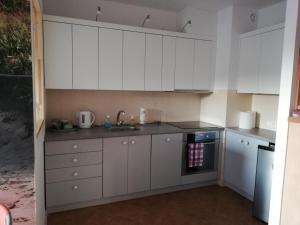 a kitchen with white cabinets and a sink at Apartament Helena in Ustka