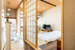 1 dormitorio con 1 cama en una habitación con puertas correderas de cristal en Minami Toji---JP Style Guesthouse in Kyoto en Kioto