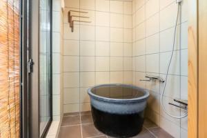 a bath tub in a bathroom with a shower at Minami Toji---JP Style Guesthouse in Kyoto in Kyoto
