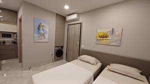 a bedroom with two beds and a kitchen at Κομψό studio με δωρεάν πάρκινγκ in Volos