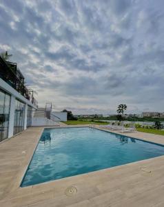 une grande piscine avec des chaises sur la terrasse dans l'établissement Luxurious 1 Bedroom Apartment Available, à Accra