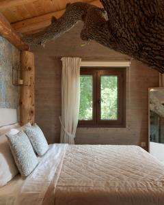 a bedroom with a large bed and a window at Stolidi Mou Treehouse in Atsipopoulo
