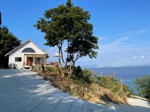 een huis op een heuvel naast de oceaan bij Pension Takahanari - Vacation STAY 06502v in Uruma