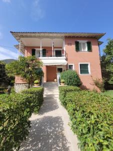 a pink house with a pathway in front of it at Villa Petros in Nydri