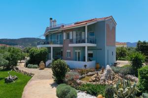 a house with a garden in front of it at Beachfront Villa Samantha's Paradise in Kivérion