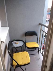 2 stoelen en een tafel op een balkon bij APARTMAN-STUDIO TEA SU in Subotica