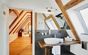 Habitación con techo de madera y baño con lavabo. en Gasthof Zum Lam, en Gleiszellen-Gleishorbach