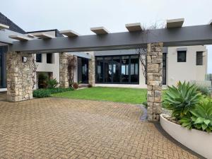 a house with a brick driveway in front of it at House Vos in Hermanus