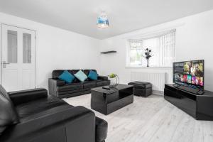 a living room with black furniture and a flat screen tv at Modern 4 bedroom home ideal for Contractors, Groups and families ,FREE parking for multiple vehicle's in Birmingham