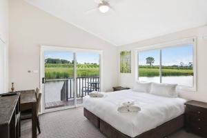 a bedroom with a bed and a desk and a window at Lovedale Lakehouse Vineyard in Lovedale