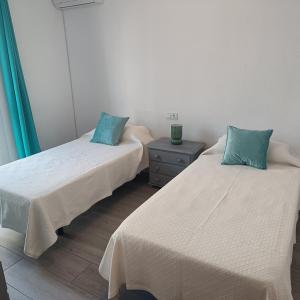 two twin beds in a room with a night stand at Duquesa Harbour Club Aparthotel in Manilva