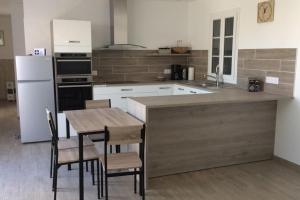 cocina con mesa, sillas y nevera en Jolie maison sur Ors (Oléron) jusqu'à 6 voyageurs en Grand-Village-Plage