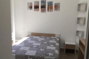 1 dormitorio con 1 cama con edredón blanco y negro en Jolie maison sur Ors (Oléron) jusqu'à 6 voyageurs, en Grand-Village-Plage