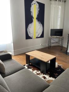 a living room with a couch and a coffee table at Appartement standing in Nevers