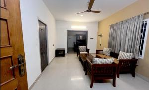 uma sala de estar com mesa e cadeiras em PPH Living Athithi Inn Corporate Stay em Coimbatore