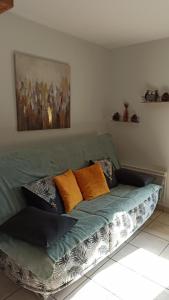 a green couch with pillows on it in a room at studio Morillon village in Morillon