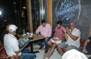 a group of men sitting around a table in a bar at قرية جراند هيلز الساحل الشمالي للعائلات فقط Grand Hills North Coast كود E45 in Dawwār ‘Abd Allāh
